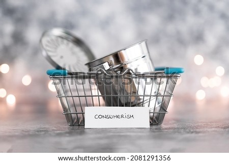 consumerism conceptual image, shopping basket symbol of good to be purchased with recycling bin symbol of excess goods being produced or bought with labels