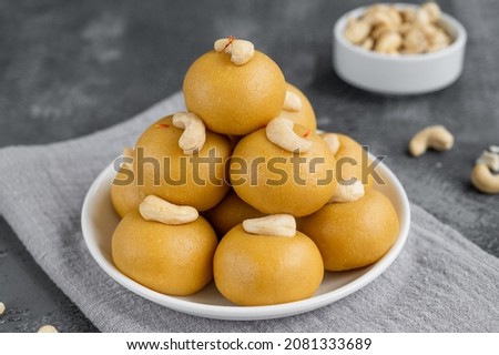 Indian sweets Besan Laddu or Laddoo on a plate on a concrete bacground. Roasted chickpea flour with ghee and sugar. Selective focus Royalty-Free Stock Photo #2081333689