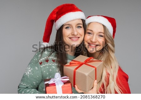 Best friends in Santa hats with Christmas presents.