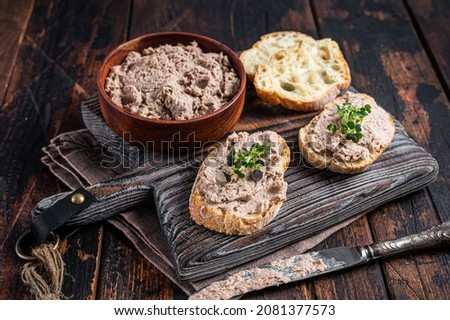 Toasts with Duck pate Rillettes de Canard on wooden board. Dark wooden background. Top View