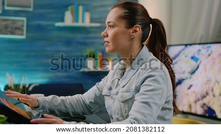 Woman photographer using touch screen software for retouching work in photography studio at home. Graphic designer working with media editing app on computer for pictures. Image artist