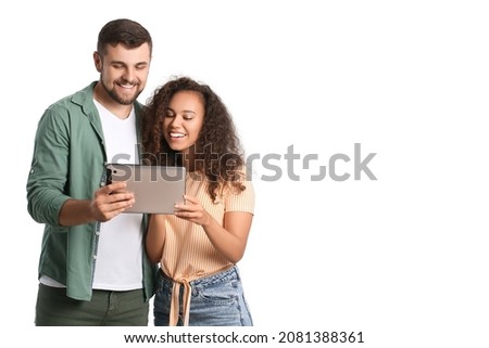 Young couple with tablet computer on white background