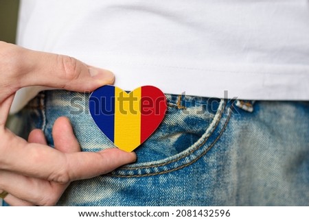 Patriot of the Romania! Wooden badge with Romania flag in the shape of a heart in a man's hand on National Unity Day. Royalty-Free Stock Photo #2081432596