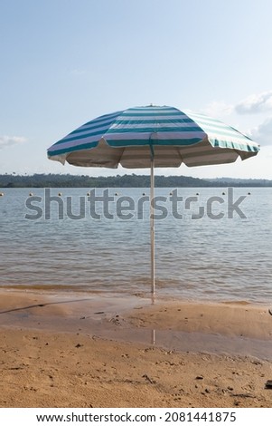Vertical photo of a beach umbrella on the Xingu River in northern Brazil.