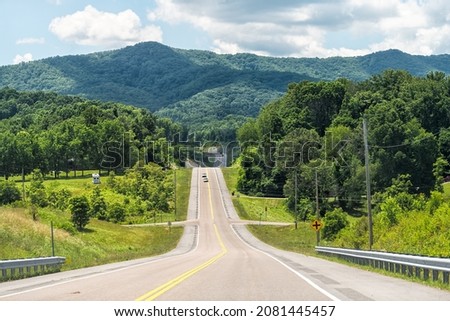 Highway road us-19e street in Roan Mountain, Tennesse with view of Beech Mountain ski resort peak scenic road trip driving with steep hills in lush green summer Royalty-Free Stock Photo #2081445457