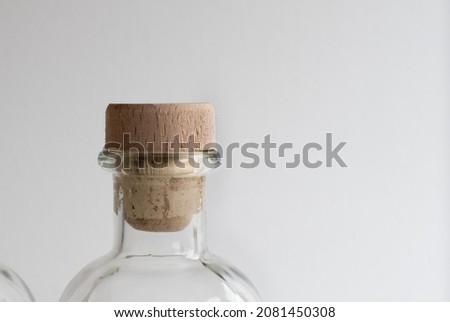 Cork stopper close up in glass transparent bottle for liquids on light background Royalty-Free Stock Photo #2081450308