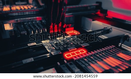 Motherboards and Computer Chips Production by Automatic SMT Pick and Place machine. Low Angle shot. Automatic SMT Pick and Place machine picks elements up and put them onto the motherboard. Royalty-Free Stock Photo #2081454559
