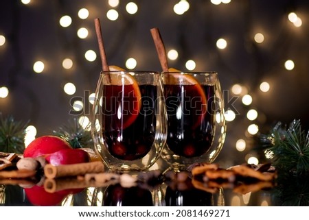 Christmas mulled wine of red wine with spices and fruits on a black background. Traditional hot drink at Christmas.