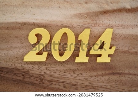 Golden Arabic numerals 2014 on a dark brown to white wood grain background.