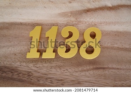 Golden Arabic numerals 1138 on a dark brown to white wood grain background.
