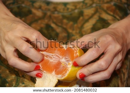 Peeling delicious ripe tangerine close-up