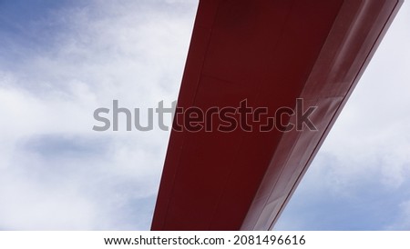 red metallic shape against cloudy sky