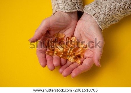 Elderly woman holds fish oil capsules in her hands. Omega 3 and old age. Royalty-Free Stock Photo #2081518705