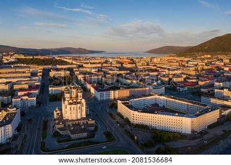 Aerial view of the city of Magadan. Beautiful morning cityscape. Top view of the Cathedral, streets and buildings illuminated by the sun at sunrise. Magadan, Magadan Region, Russian Far East. Russia. Royalty-Free Stock Photo #2081536684