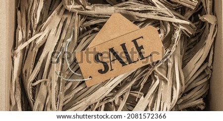 Black Friday. Sale tag on the paper filler. Zero waste shopping concept, flat lay, top view, banner format