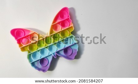 Rainbow color Pop is a toy in the shape of a butterfly on a white background