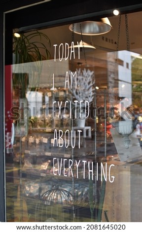 Positive inspiring message written on a glass wall of a retail storefront