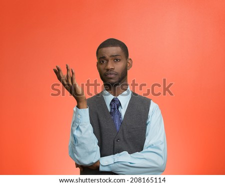 Closeup portrait dumb clueless young executive man, arm out asking why what problem so who cares, I don't know, isolated red color background. Negative human emotion facial expression feelings