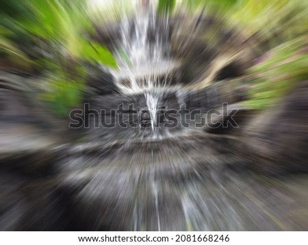 a mock waterfall with blurred green grass used as a background