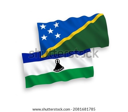 National vector fabric wave flags of Solomon Islands and Lesotho isolated on white background. 1 to 2 proportion.