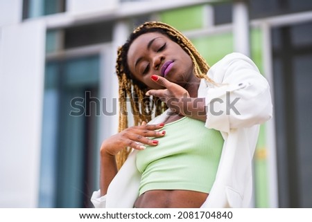 Beauty african woman dancing with passion in front of a modern building