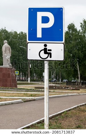 Road sign parking for disabled people stands in city.