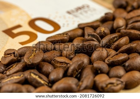 Roasted coffee beans together with 50 euro bill. High price of coffee. Pictute taken in good artificial light. 