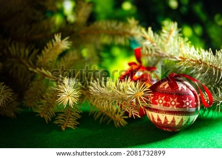 red Christmas balls for decoration on the background of green spruce branches.