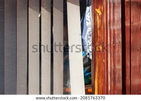vertical window blinds behind a glass, outdoor close up shot