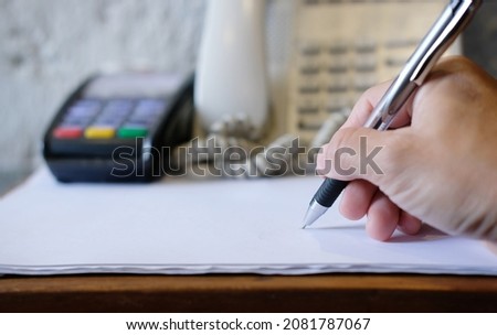 The idea of an unidentified business person signing documents at the office during the day