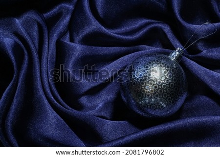 silver christmas ball on blue satin background