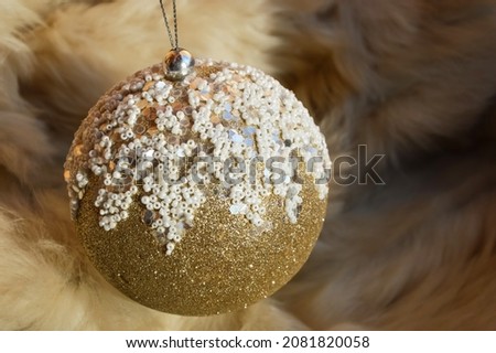 a shiny Christmas ball with white beads on a fur background. Decoration for Christmas and New Year. winter holidays.