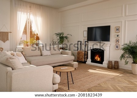 Stylish living room with comfortable sofas, modern TV and fireplace. Interior design