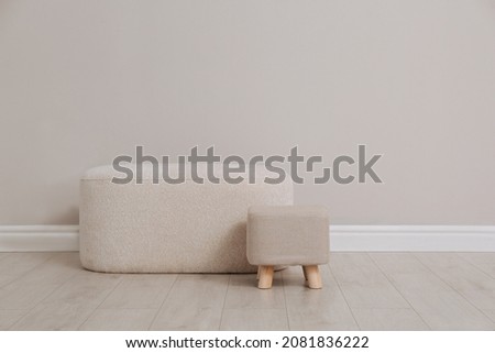 Stylish poufs near beige wall indoors. Space for text Royalty-Free Stock Photo #2081836222
