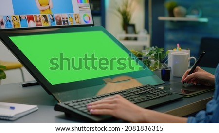 Close up of horizontal green screen on computer with retouching app. Photographer editing pictures with graphic tablet while having chroma key with mockup template and isolated background