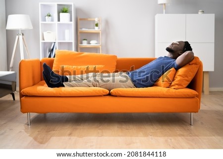 African American Man Relaxing On Sofa Or Couch Royalty-Free Stock Photo #2081844118