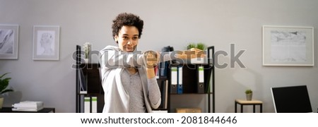 Stretching Exercise At Desk. African American Woman At Workplace Royalty-Free Stock Photo #2081844646