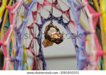 dream catcher, handicraft made with wicker and colored wool. dream catcher made by hand with a stone in the center