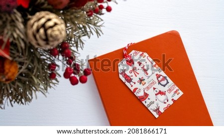 Christmas concept, top view of Christmas card on orange notebook with pine tree decoration, selective focus
