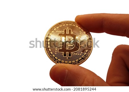 macro of golden radiance on physical real bit coin between the fingers - signs of cyberspace concept