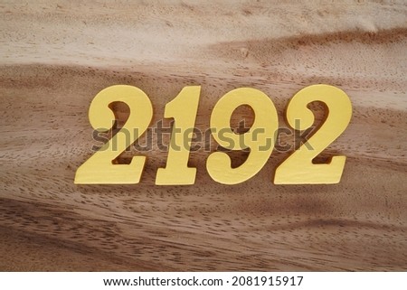 Golden Arabic numerals 2192 on a dark brown to white wood grain background.
