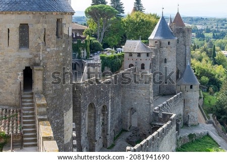 View over fortified wall with battlement and towers towards French landscape of the city of Carcassonne, a medieval fortress from Gallo-Roman period and part of UNESCO list of World Heritage Sites Royalty-Free Stock Photo #2081941690