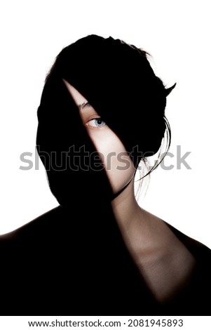Fashionable studio portrait of a cute girl. Silhouette of a beautiful young woman with hard shadows on her face. against white backgroung.