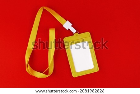 Yellow case with white blank badge on red background