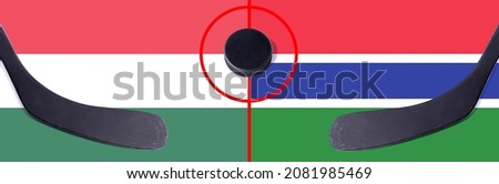 Top view hockey puck with Hungary vs. Gambia command with the sticks on the flag. Concept hockey competitions