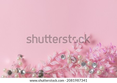 Minimalism style festive composition with dry plants and silver decorations on pink background. Christmas and New Year greeting card mock up.