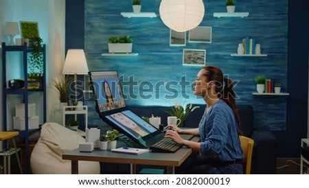 Woman photographer doing retouch work at studio, using image editing software on touch screen monitor. Graphic designer retouching professional pictures with media production equipment