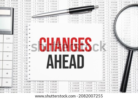 Changes Ahead text on paper with calculator,magnifier ,pen on the graph background
