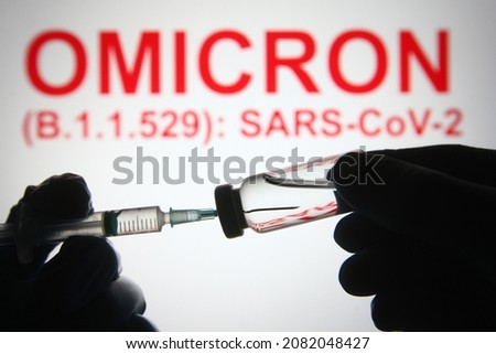 In this photo illustration of a new COVID-19 variant a medical syringe and a vial are seen and Omicron (B.1.1.529): SARS-CoV-2 words in the white background. select focus Royalty-Free Stock Photo #2082048427