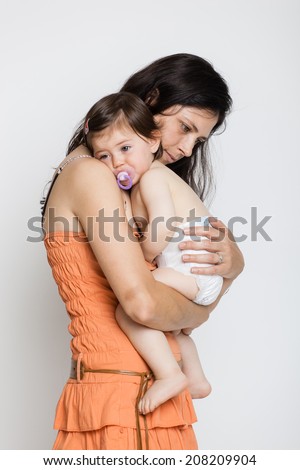 Crying baby girl with her mother isolated on white